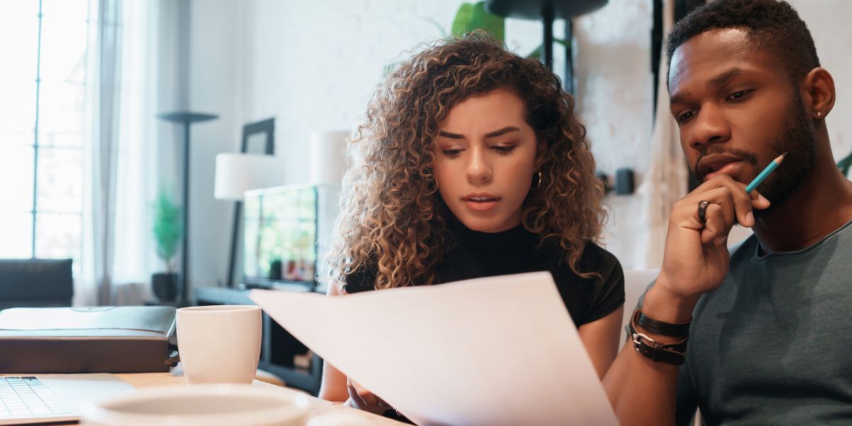 A couple reviewing homebuying budget documents together while planning a home purchase.