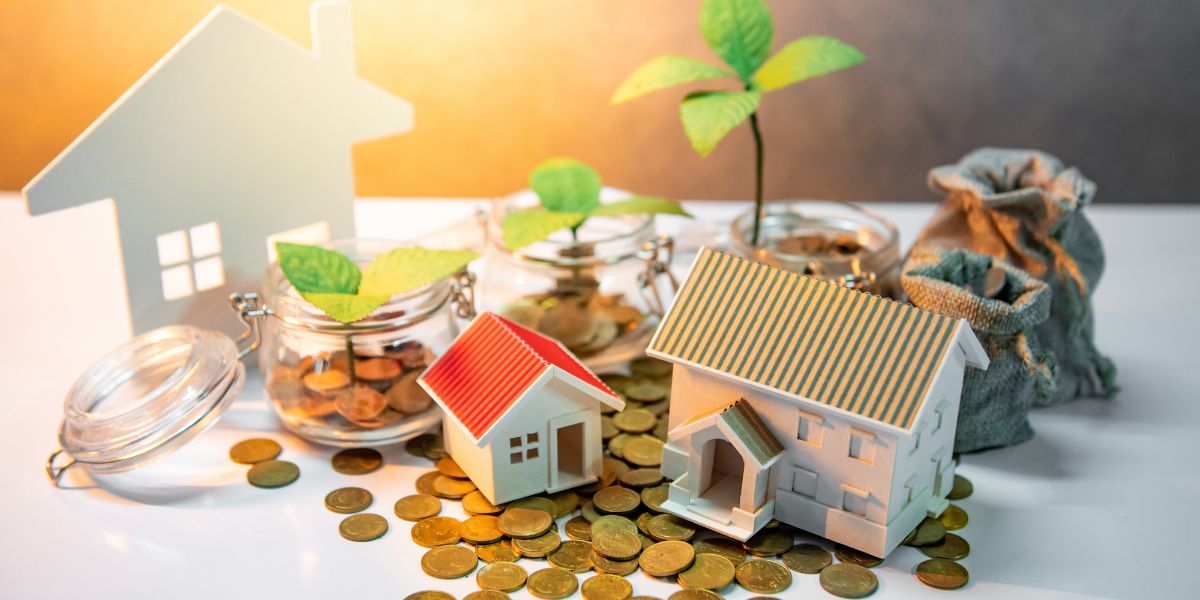 Small model houses and jars filled with coins, with green plants growing from the jars, symbolizing financial growth.